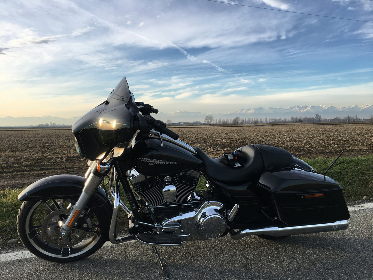 Black Harley-Davidson Street Glide 103 parked by a field at sunset